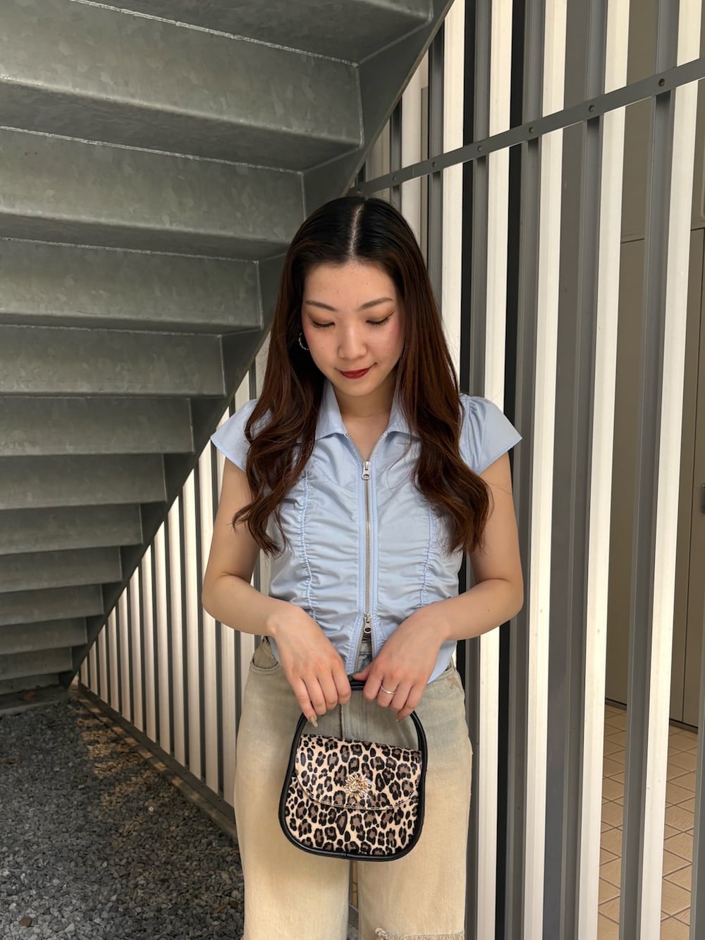 ベージュ系のデニムパンツ、ブラック系のブーツ、ブルー系のシャツ/ブラウスを着用したレディースの春コーディネートの4枚目の写真