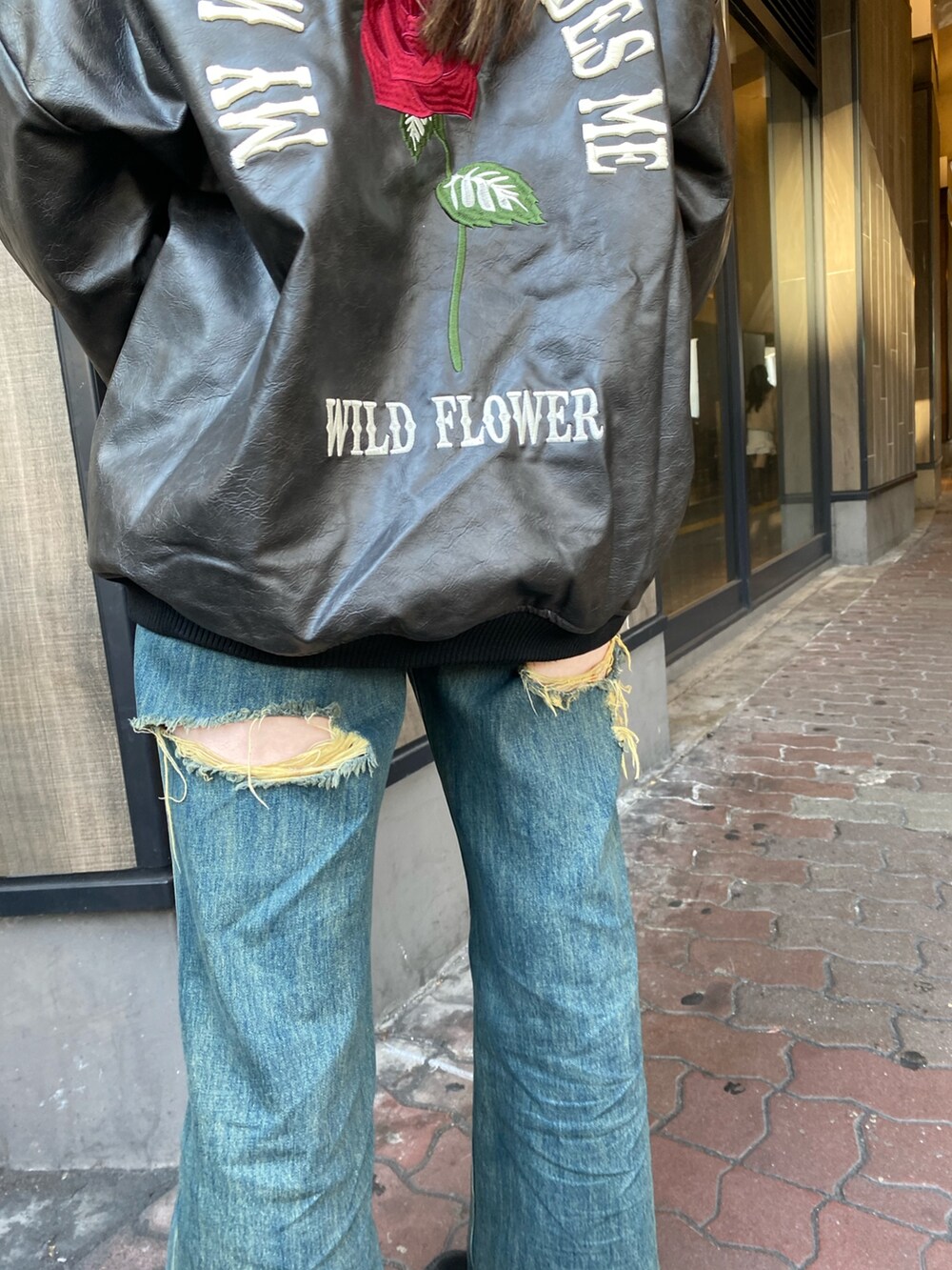 ブルー系のデニムパンツ、ブラック系のブーツ、ブラック系のスタジャンを着用したレディースの冬コーディネートの7枚目の写真