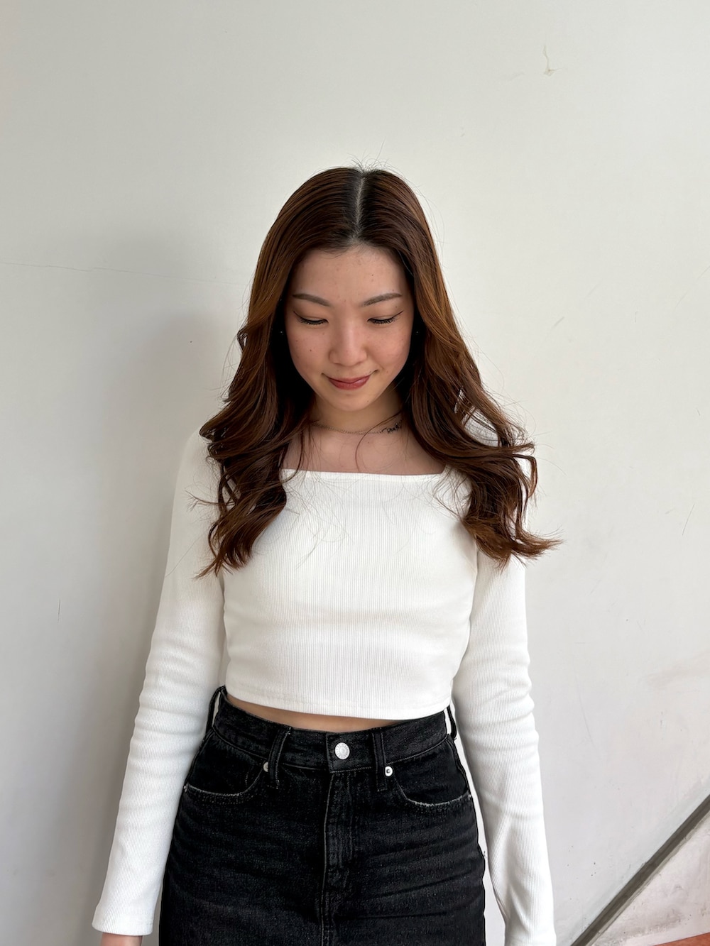 ホワイト系のTシャツ/カットソー、ブラック系のデニムスカート、ブラック系のパンプスを着用したレディースの春コーディネートの4枚目の写真