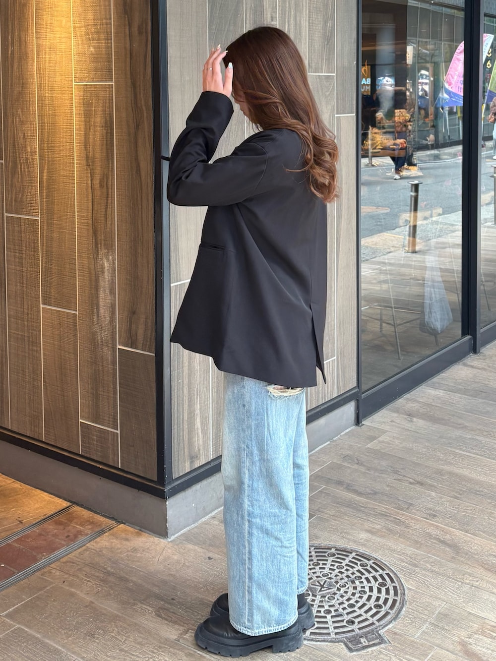 ブルー系のデニムパンツ、ブラック系のブーツ、ホワイト系のTシャツ/カットソーを着用したレディースの春コーディネートの2枚目の写真