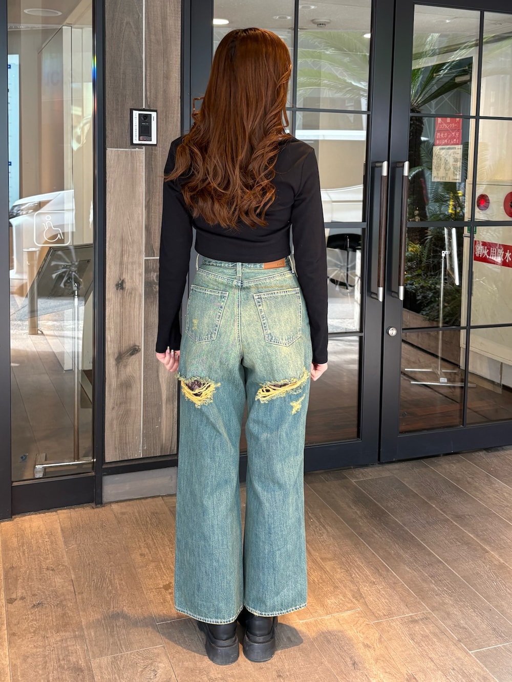 ブラック系のTシャツ/カットソー、ブルー系のデニムパンツ、ブラック系のブーツを着用したレディースの春コーディネートの3枚目の写真