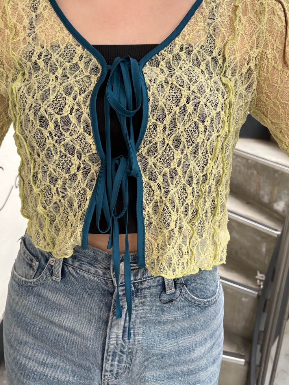 ホワイト系のパンプス、ブルー系のデニムパンツ、イエロー系のカーディガン/ボレロを着用したレディースの春コーディネートの5枚目の写真