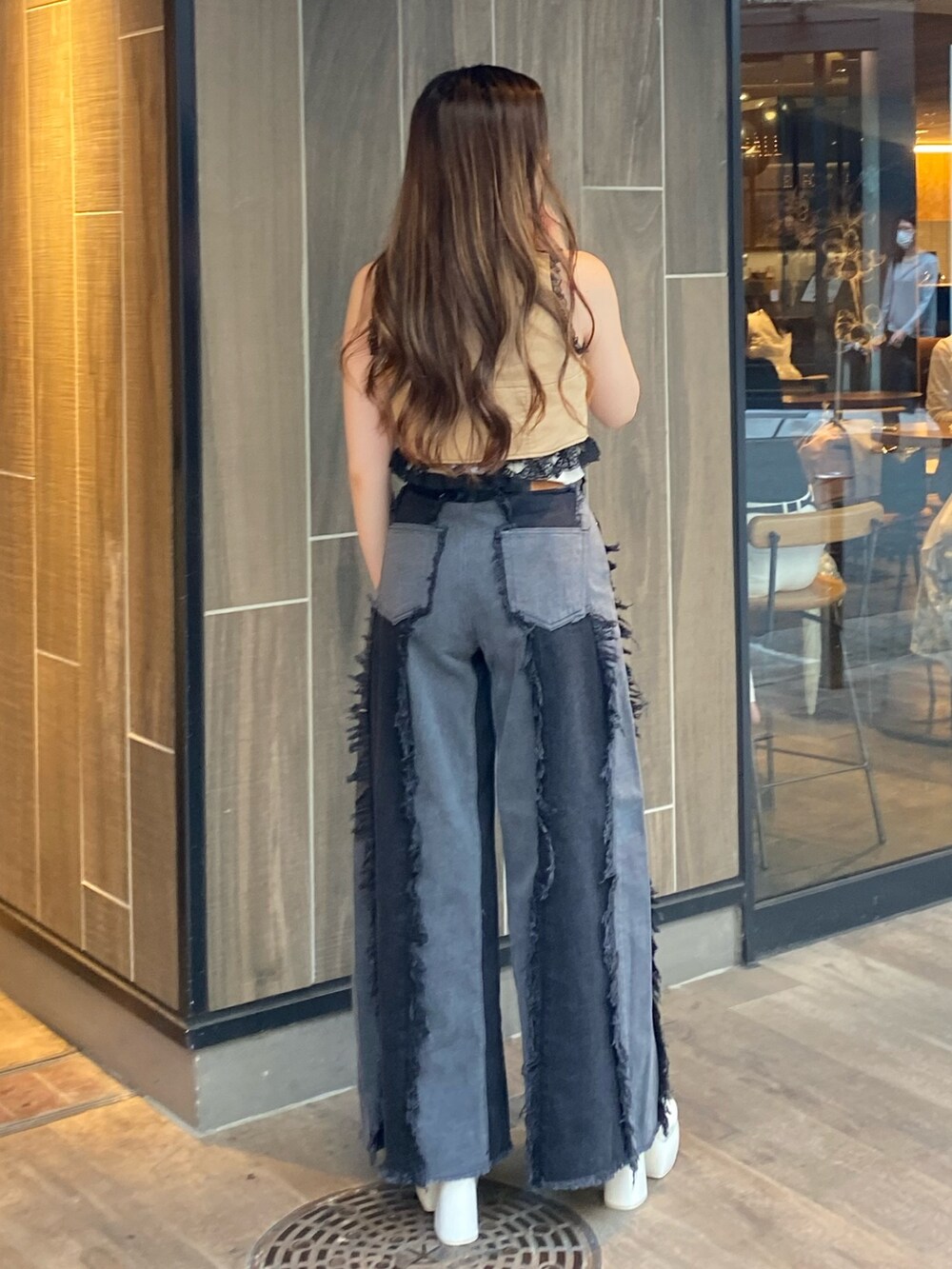 ブラック系のデニムパンツ、ブルー系のキャミソール、ベージュ系のシャツ/ブラウスを着用したレディースの夏コーディネートの3枚目の写真