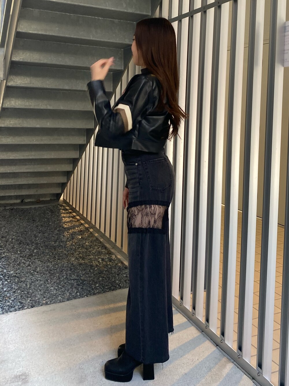 ブラック系のデニムパンツ、ブラック系のブーツ、ブラック系のライダースジャケットを着用したレディースの秋コーディネートの2枚目の写真