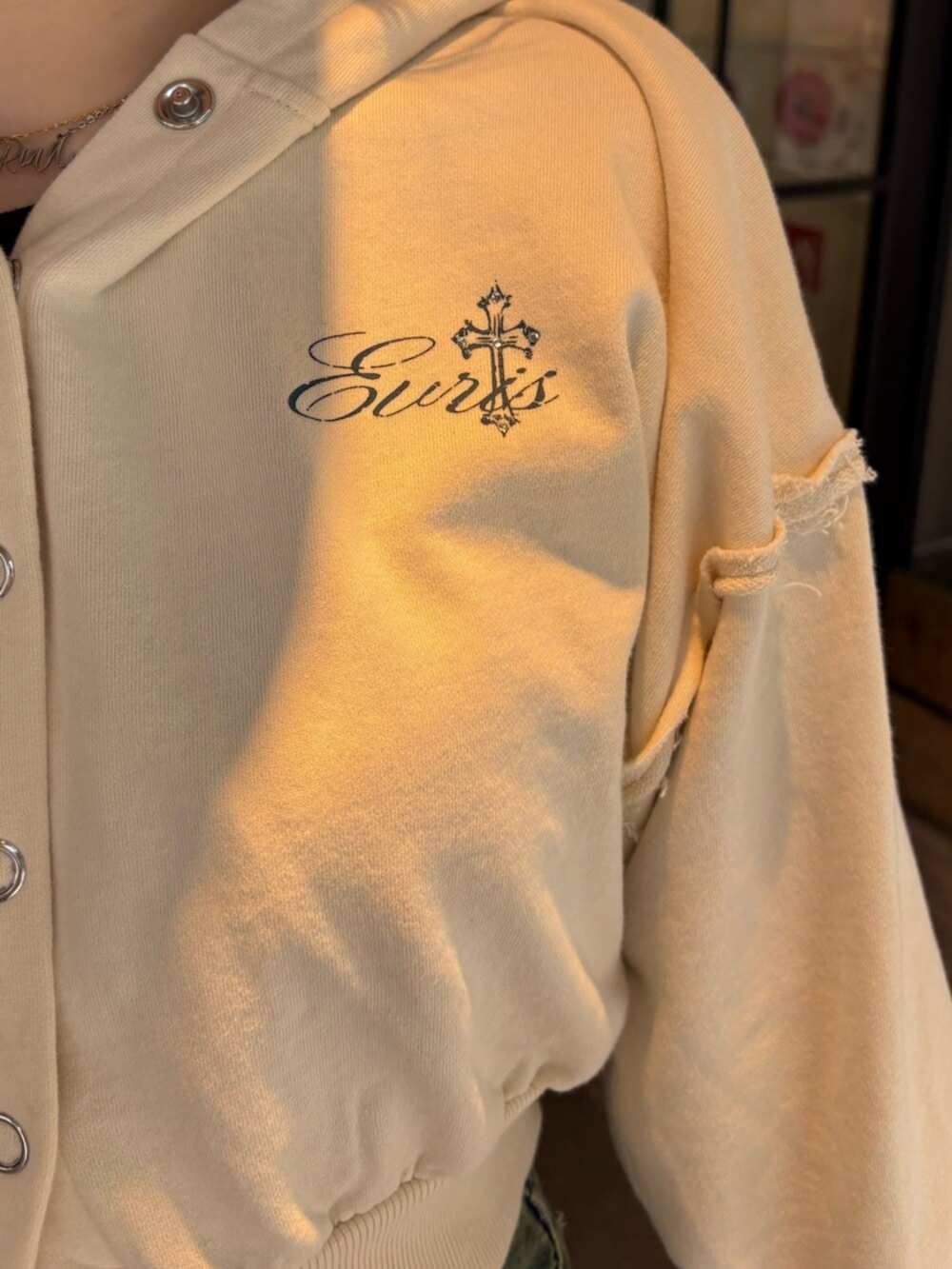 ブラック系のブーツ、ブルー系のデニムパンツ、ホワイト系のパーカーを着用したレディースの春コーディネートの5枚目の写真