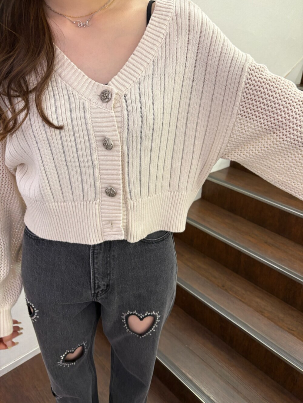 ブラック系のブーツ、ホワイト系のカーディガン/ボレロ、ブラック系のデニムパンツを着用したレディースの春コーディネートの5枚目の写真