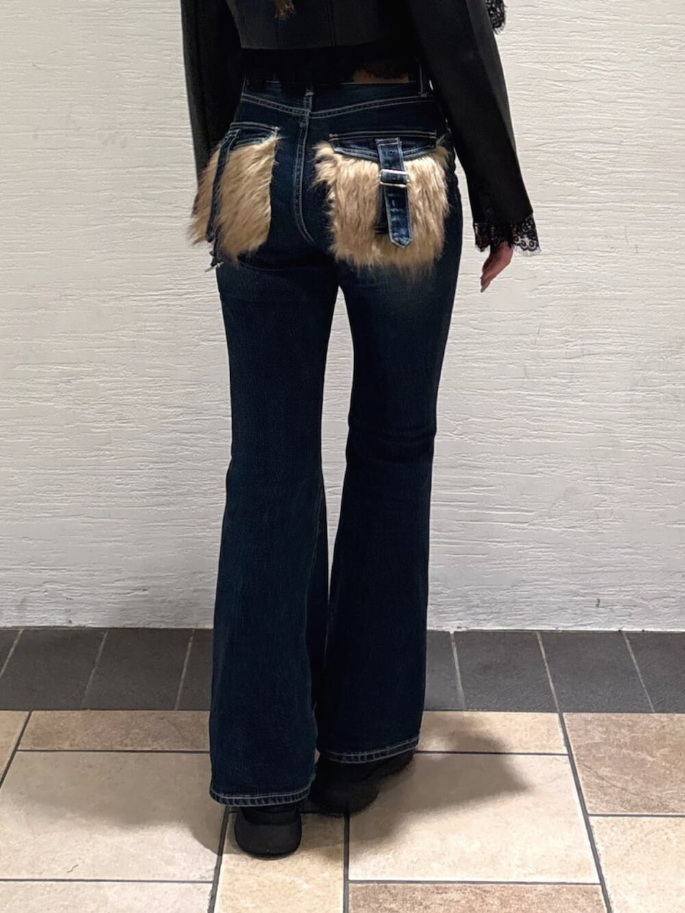 ブルー系のデニムパンツ、ブラック系のブーツ、ブラック系のTシャツ/カットソーを着用したレディースの秋コーディネートの6枚目の写真