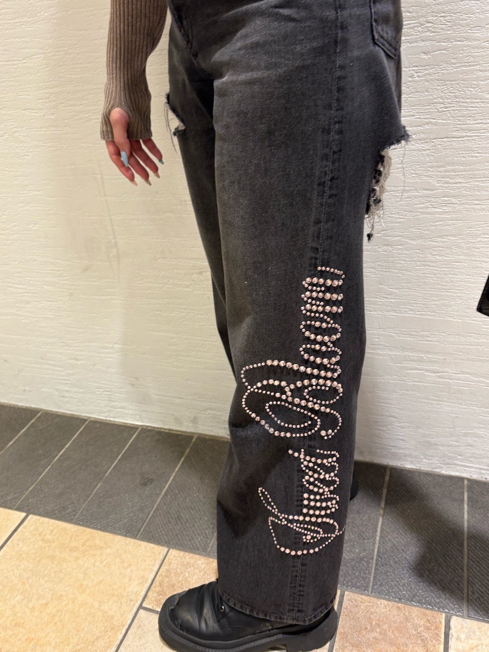 ブラック系のショルダーバッグ、ブラック系のデニムパンツ、ブラック系のブーツを着用したレディースの秋コーディネートの6枚目の写真