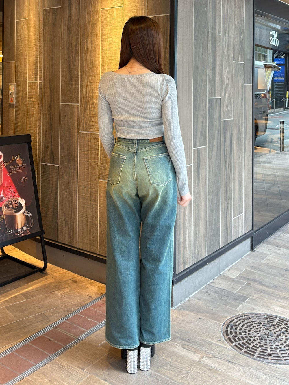 グレー系のニット/セーター、ブルー系のデニムパンツ、ブラック系のブーツを着用したレディースの冬コーディネートの3枚目の写真