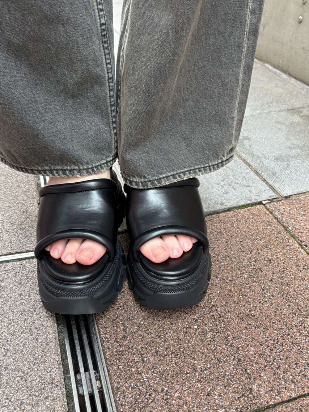 ブラック系のサンダル、ブラック系のデニムパンツ、ブルー系のニット/セーターを着用したレディースの夏コーディネートの6枚目の写真