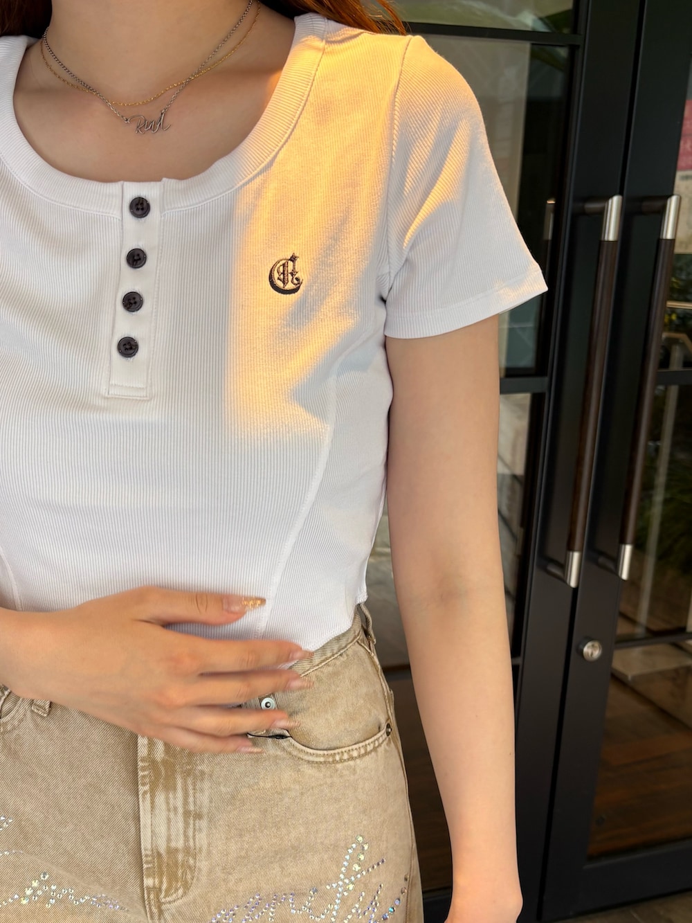 ブラウン系のボストンバッグ、ベージュ系のデニムパンツ、ブラック系のブーツを着用したレディースの夏コーディネートの5枚目の写真