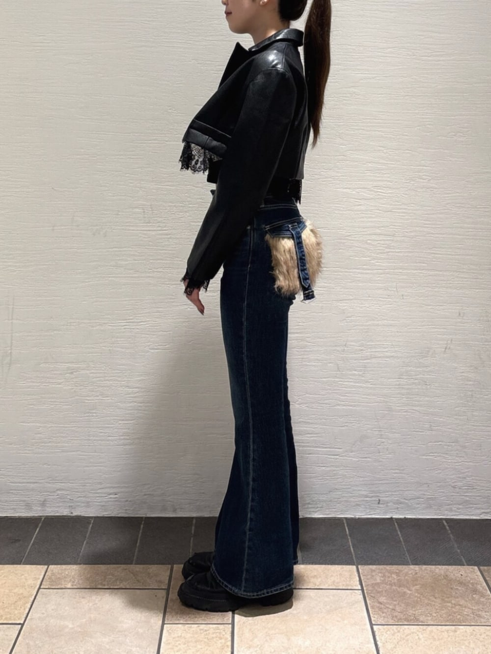 ブルー系のデニムパンツ、ブラック系のブーツ、ブラック系のTシャツ/カットソーを着用したレディースの秋コーディネートの2枚目の写真