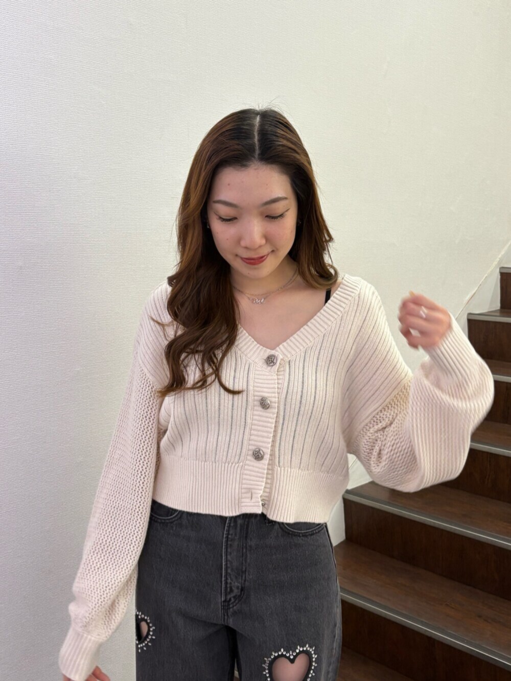 ブラック系のブーツ、ホワイト系のカーディガン/ボレロ、ブラック系のデニムパンツを着用したレディースの春コーディネートの4枚目の写真