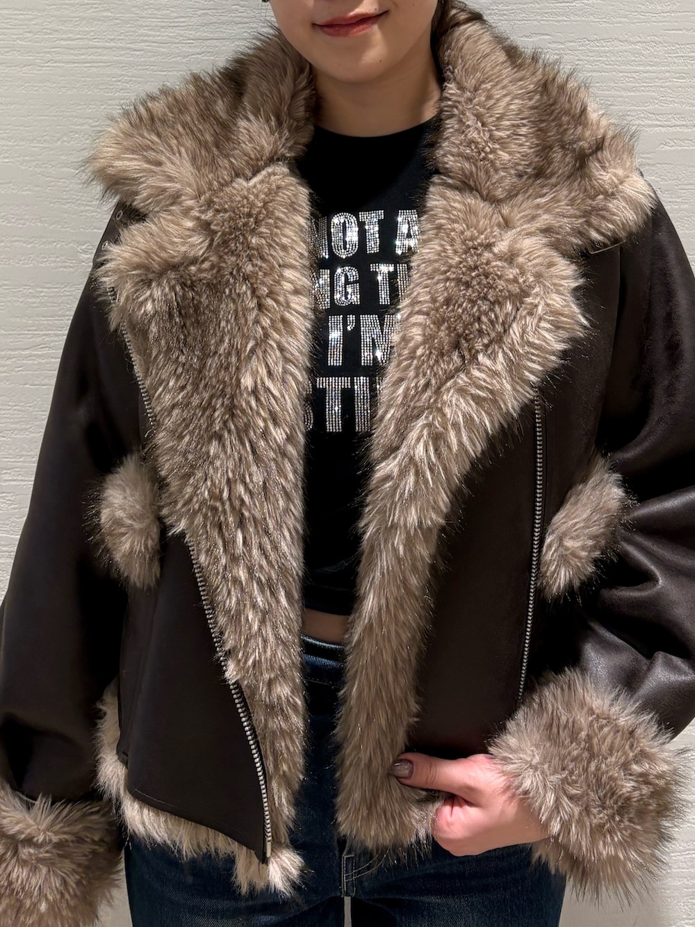 ブルー系のデニムパンツ、ブラック系のブーツ、ブラウン系のブルゾンを着用したレディースの秋コーディネートの4枚目の写真