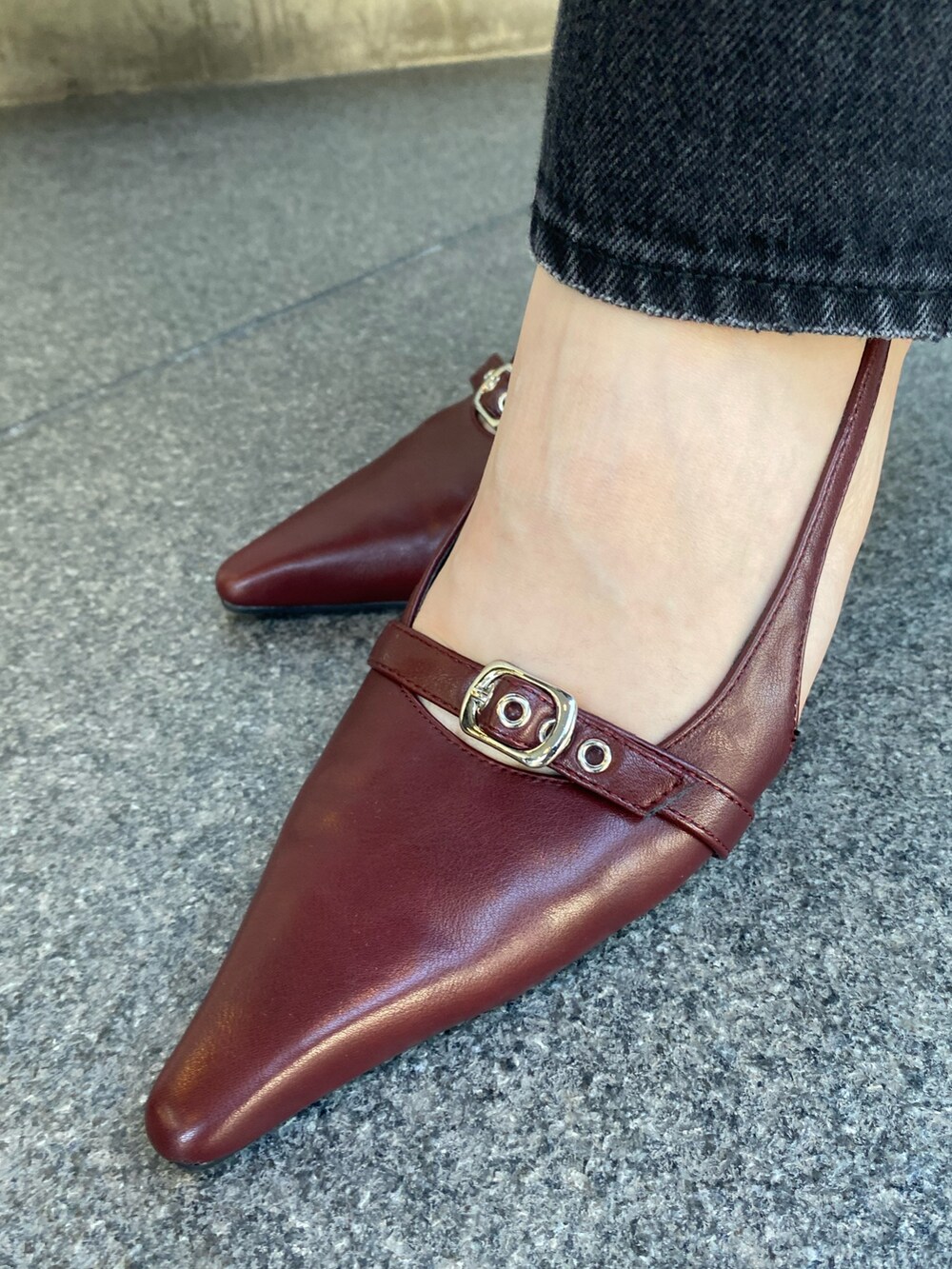 ブラック系のデニムパンツ、ブラウン系のニット/セーター、レッド系のショルダーバッグを着用したレディースの秋コーディネートの7枚目の写真