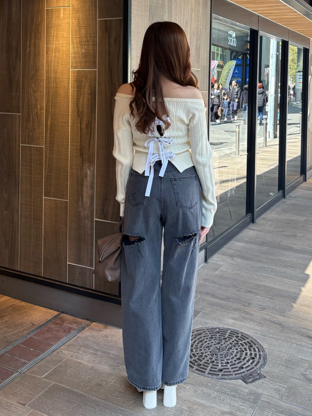 ホワイト系のニット/セーター、ブラック系のデニムパンツ、ブラウン系のボストンバッグを着用したレディースの冬コーディネートの3枚目の写真