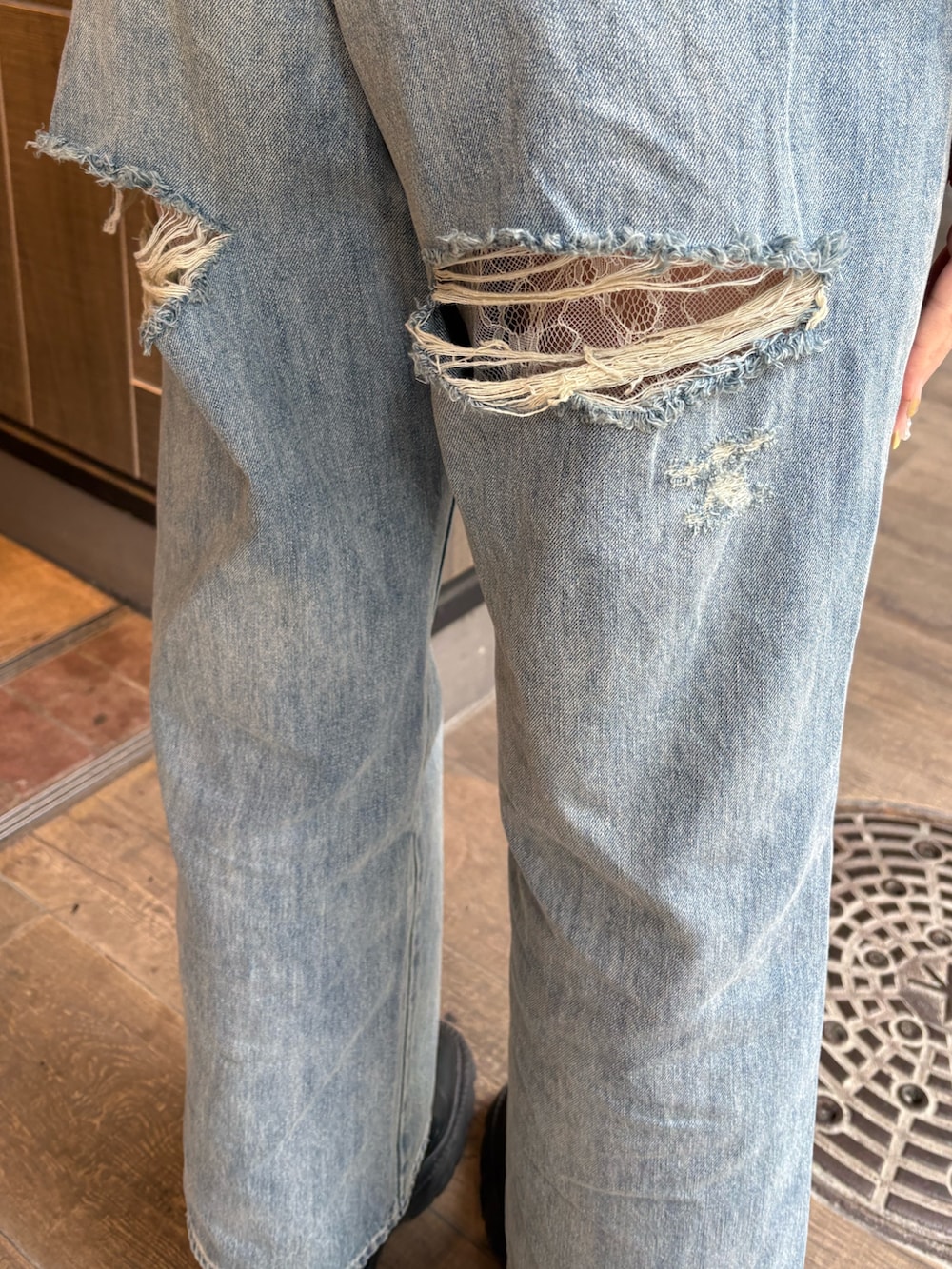 ホワイト系のTシャツ/カットソー、ブルー系のデニムパンツ、ブラック系のブーツを着用したレディースの春コーディネートの6枚目の写真