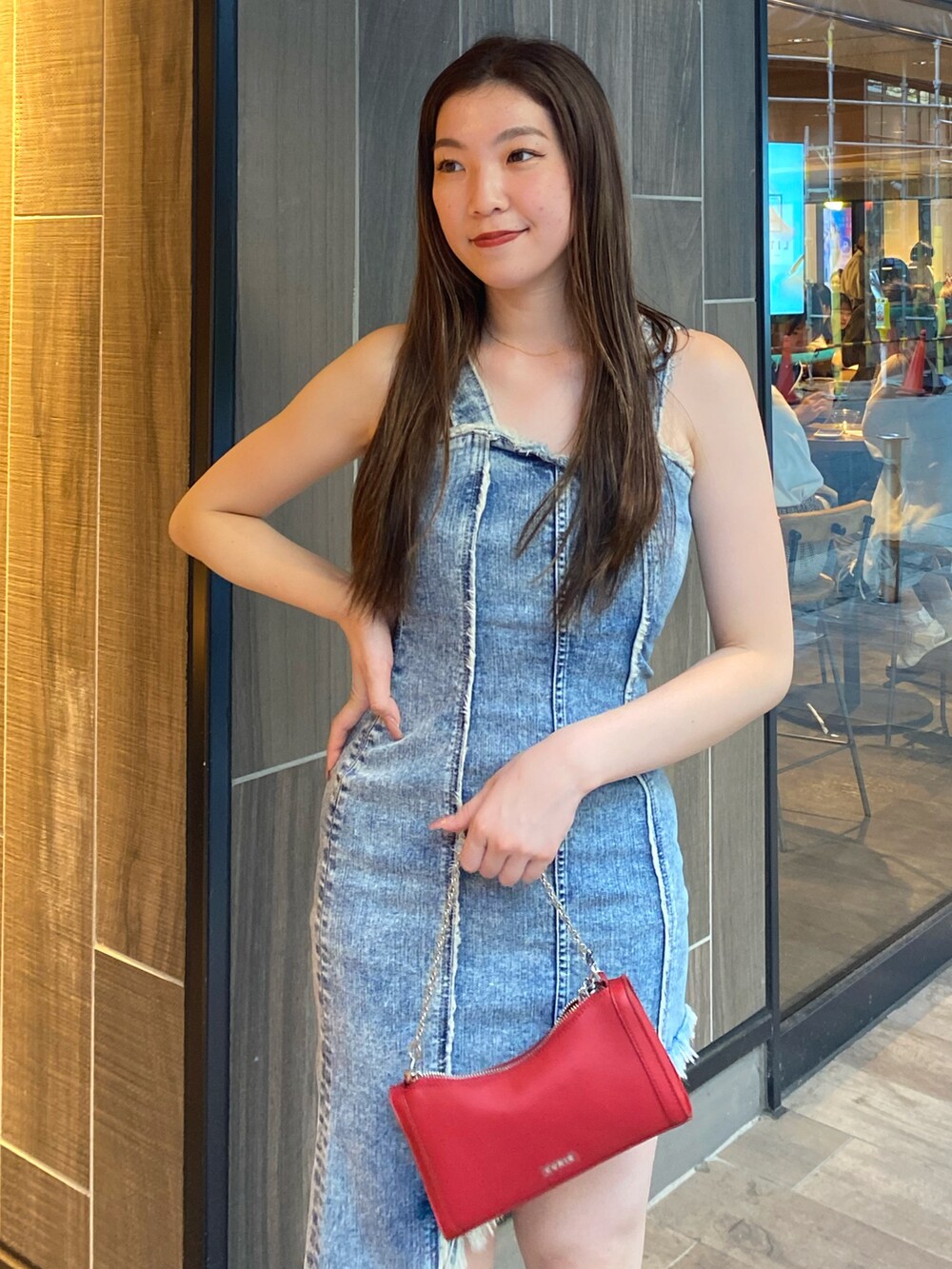 ブルー系のワンピース、レッド系のショルダーバッグ、ブラック系のブーツを着用したレディースの夏コーディネートの4枚目の写真