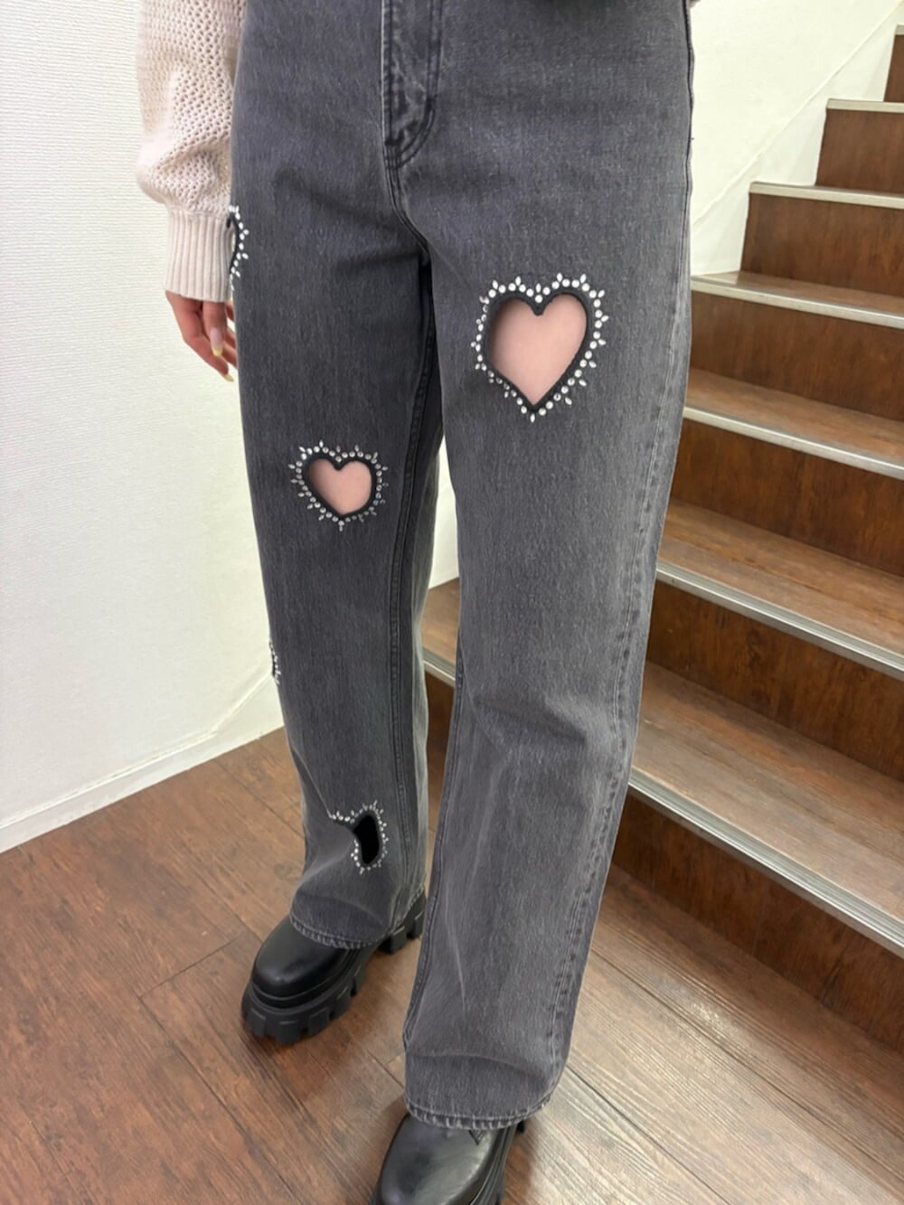 ブラック系のブーツ、ホワイト系のカーディガン/ボレロ、ブラック系のデニムパンツを着用したレディースの春コーディネートの6枚目の写真