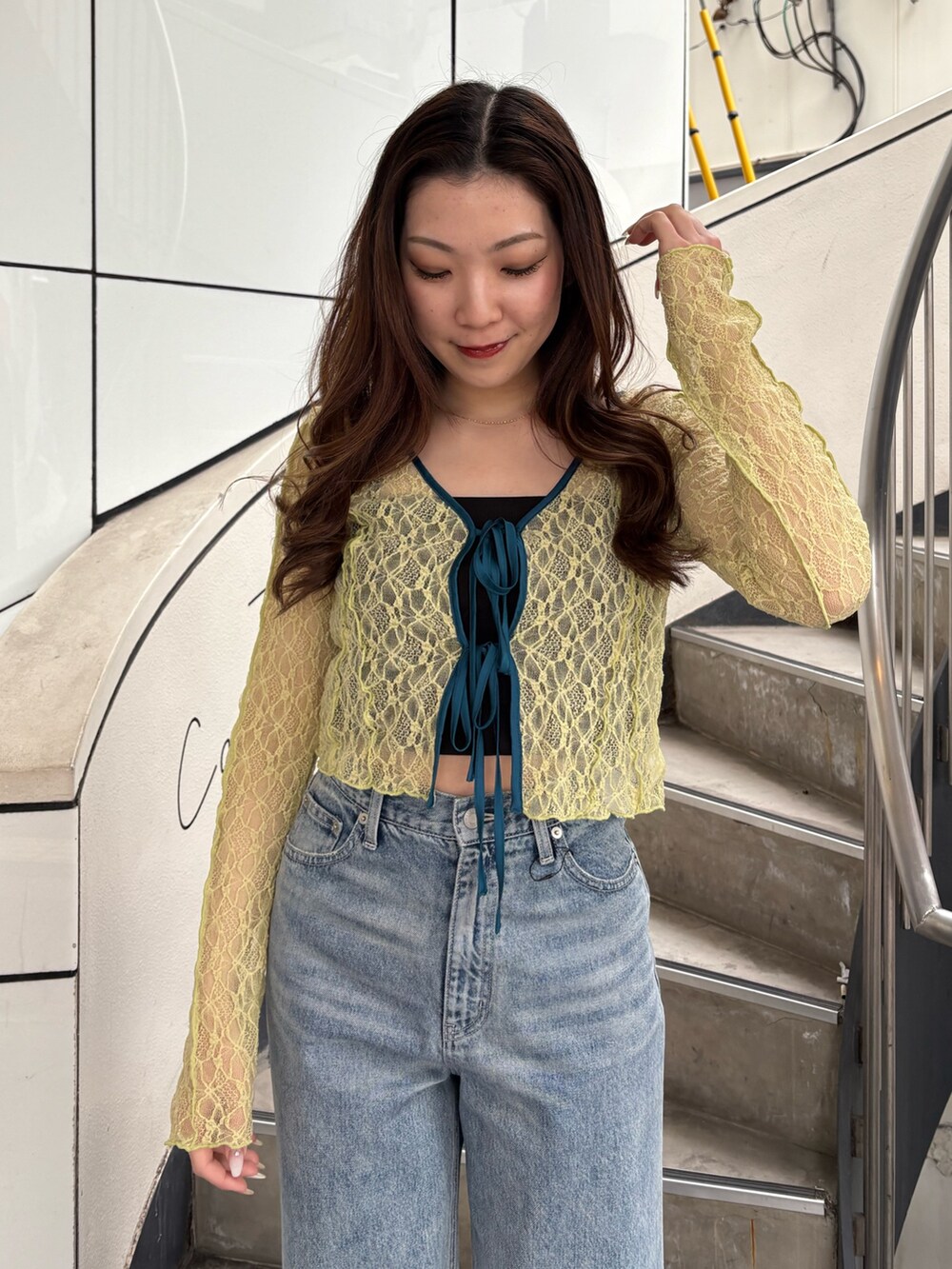 ホワイト系のパンプス、ブルー系のデニムパンツ、イエロー系のカーディガン/ボレロを着用したレディースの春コーディネートの4枚目の写真