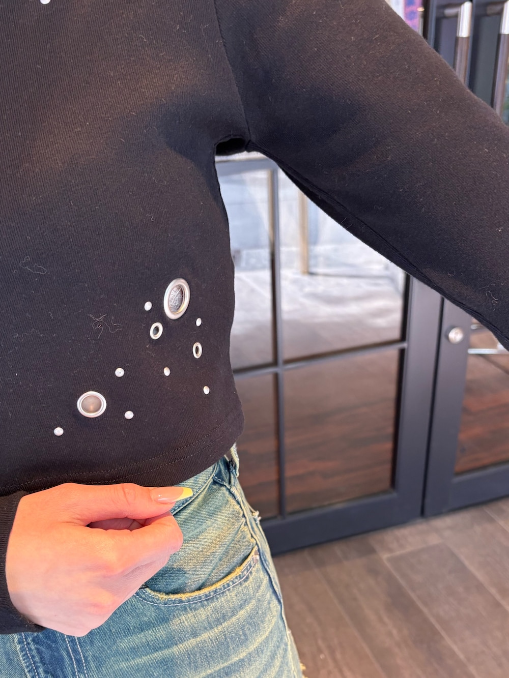 ブラック系のTシャツ/カットソー、ブルー系のデニムパンツ、ブラック系のブーツを着用したレディースの春コーディネートの5枚目の写真