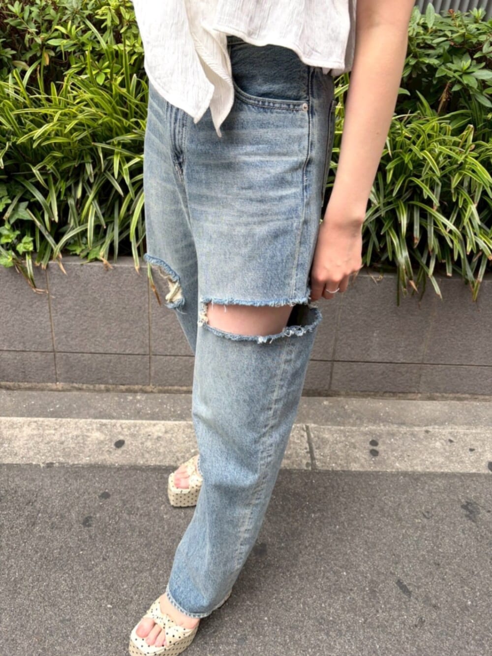 ホワイト系のキャミソール、ブルー系のデニムパンツ、ホワイト系のサンダルを着用したレディースの夏コーディネートの6枚目の写真