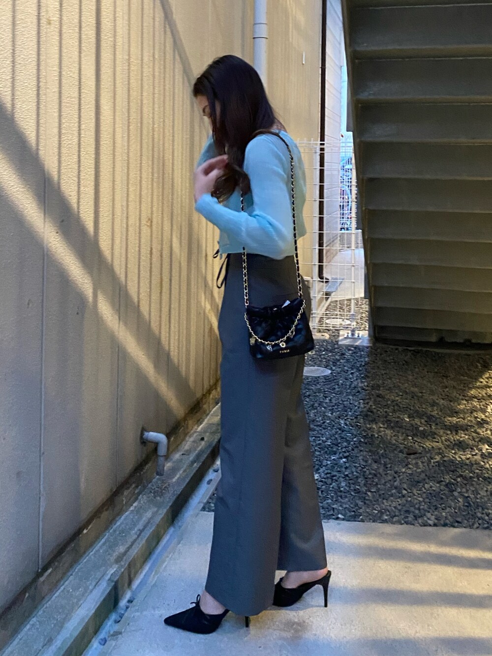 ブルー系のニット/セーター、グレー系のその他パンツ、ブラック系のサンダルを着用したレディースの春コーディネートの2枚目の写真