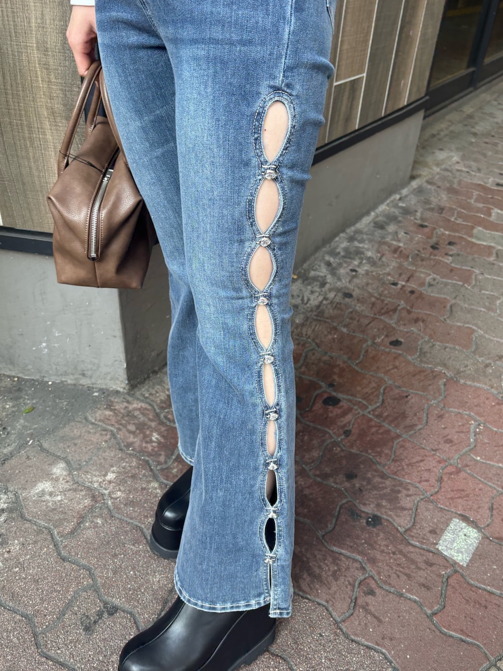 ホワイト系のTシャツ/カットソー、ブルー系のデニムパンツ、ブラック系のブーツを着用したレディースの冬コーディネートの6枚目の写真