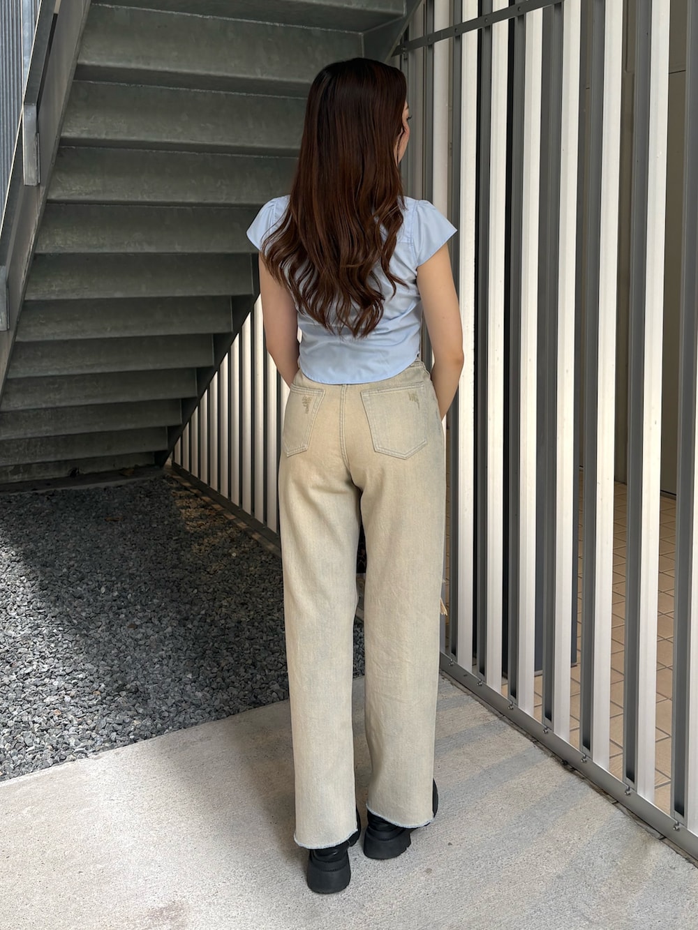 ベージュ系のデニムパンツ、ブラック系のブーツ、ブルー系のシャツ/ブラウスを着用したレディースの春コーディネートの3枚目の写真