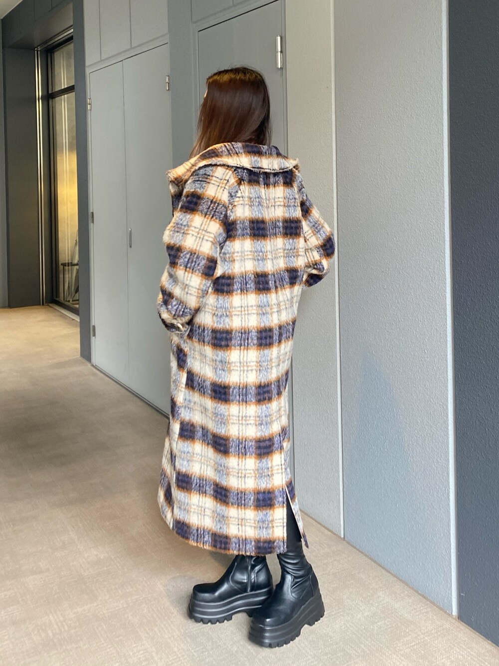 その他のチェスターコート、ホワイト系のスウェット、ブラック系のブーツを着用したレディースの秋コーディネートの2枚目の写真