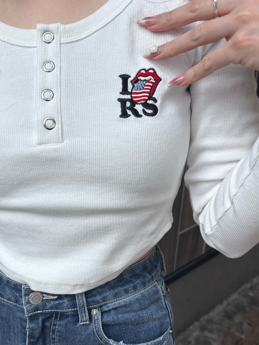 ホワイト系のTシャツ/カットソー、ブルー系のデニムパンツ、ブラック系のブーツを着用したレディースの冬コーディネートの5枚目の写真
