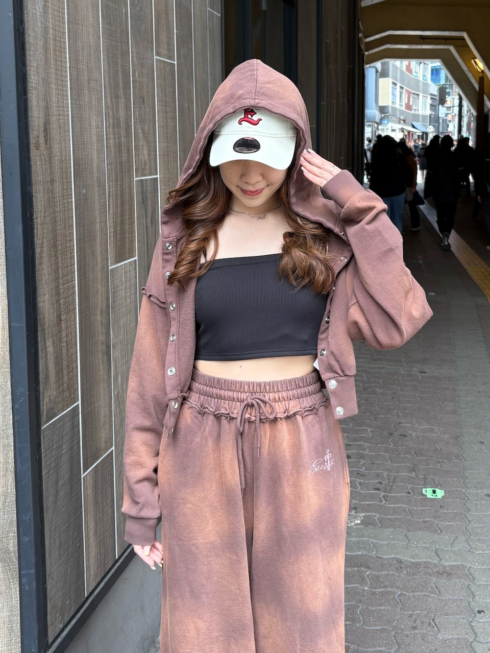 ブラウン系のスウェットパンツ、ブラック系のブーツ、ブラウン系のパーカーを着用したレディースの春コーディネートの4枚目の写真