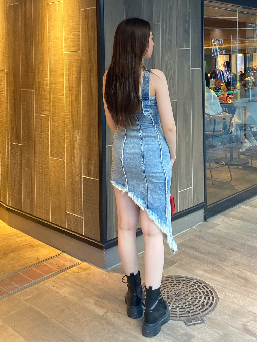 ブルー系のワンピース、レッド系のショルダーバッグ、ブラック系のブーツを着用したレディースの夏コーディネートの3枚目の写真