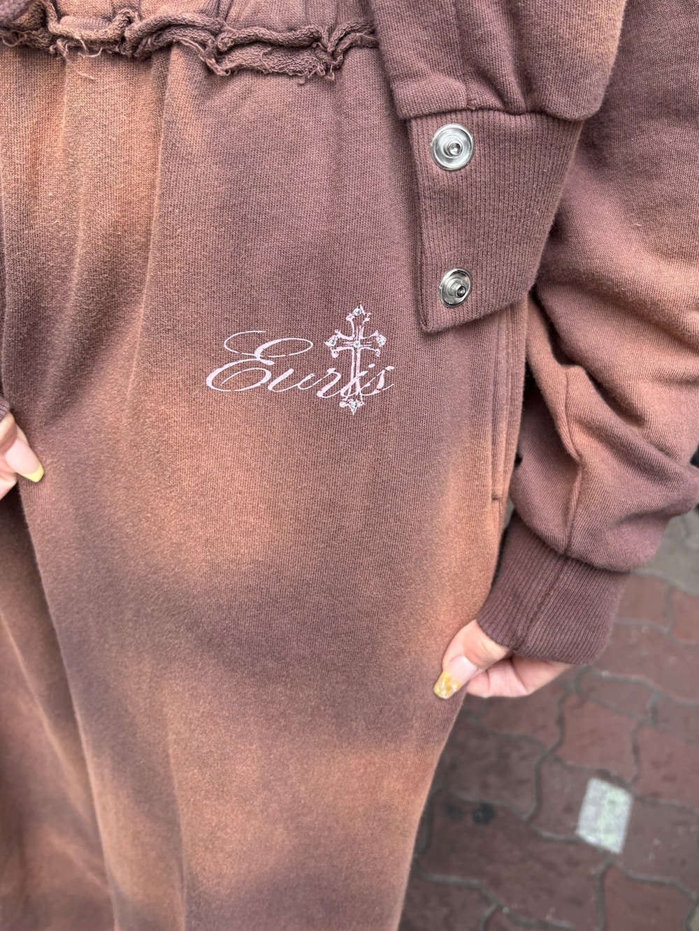 ブルー系のデニムジャケット、ブラウン系のスウェットパンツ、ブラック系のブーツを着用したレディースの春コーディネートの6枚目の写真