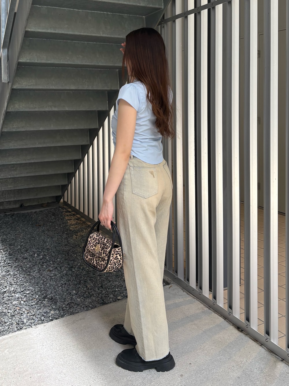 ベージュ系のデニムパンツ、ブラック系のブーツ、ブルー系のシャツ/ブラウスを着用したレディースの春コーディネートの2枚目の写真