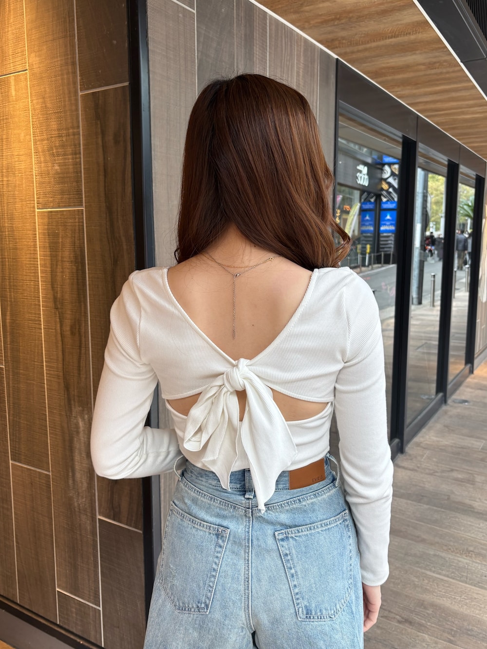 ホワイト系のTシャツ/カットソー、ブルー系のデニムパンツ、ブラック系のブーツを着用したレディースの春コーディネートの4枚目の写真