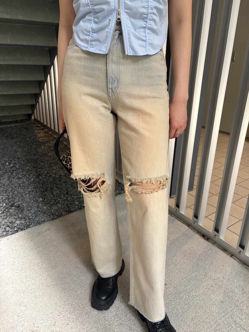 ベージュ系のデニムパンツ、ブラック系のブーツ、ブルー系のシャツ/ブラウスを着用したレディースの春コーディネートの6枚目の写真