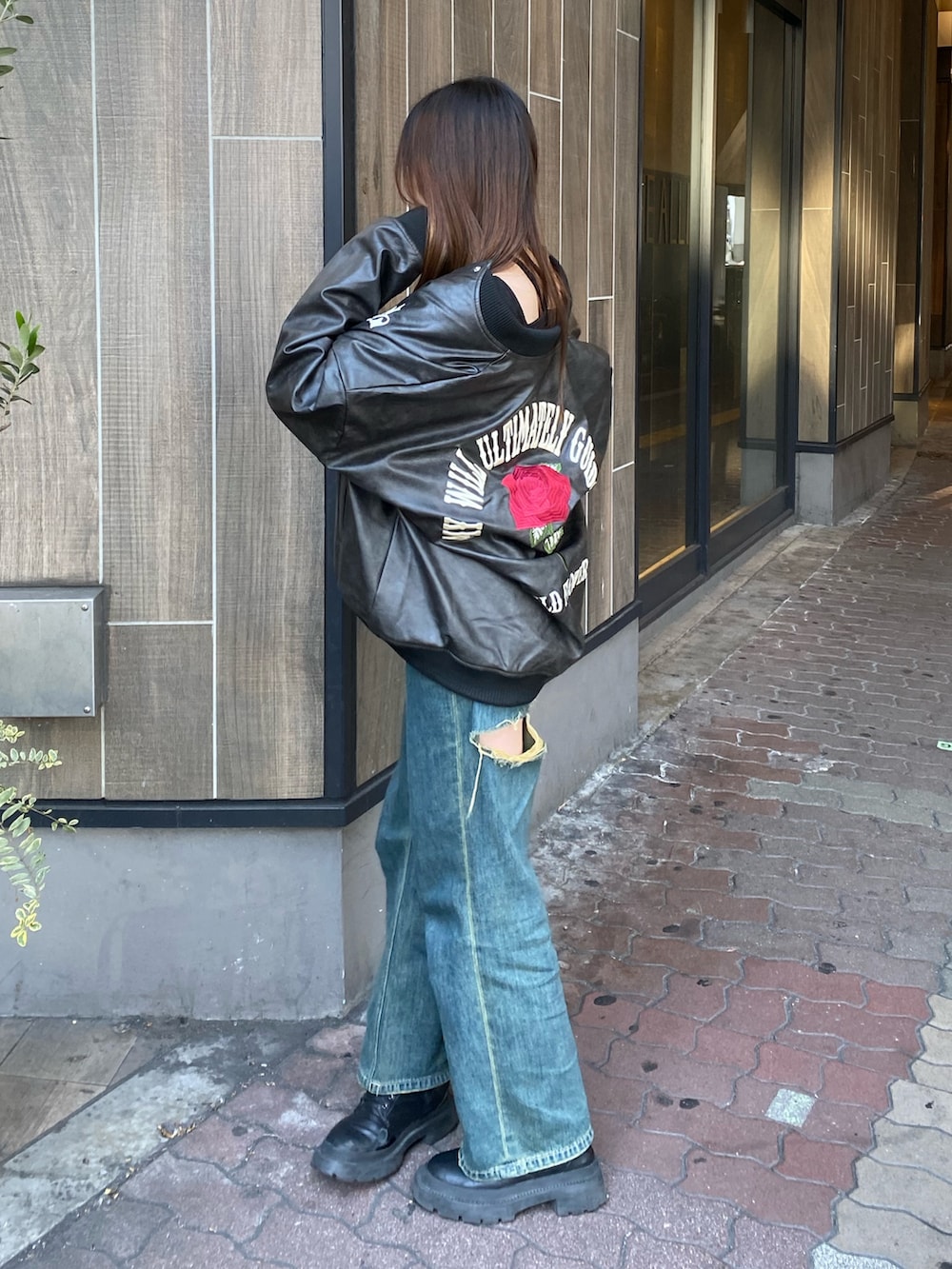 ブルー系のデニムパンツ、ブラック系のブーツ、ブラック系のスタジャンを着用したレディースの冬コーディネートの2枚目の写真