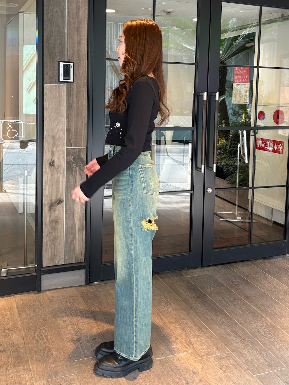 ブラック系のTシャツ/カットソー、ブルー系のデニムパンツ、ブラック系のブーツを着用したレディースの春コーディネートの2枚目の写真