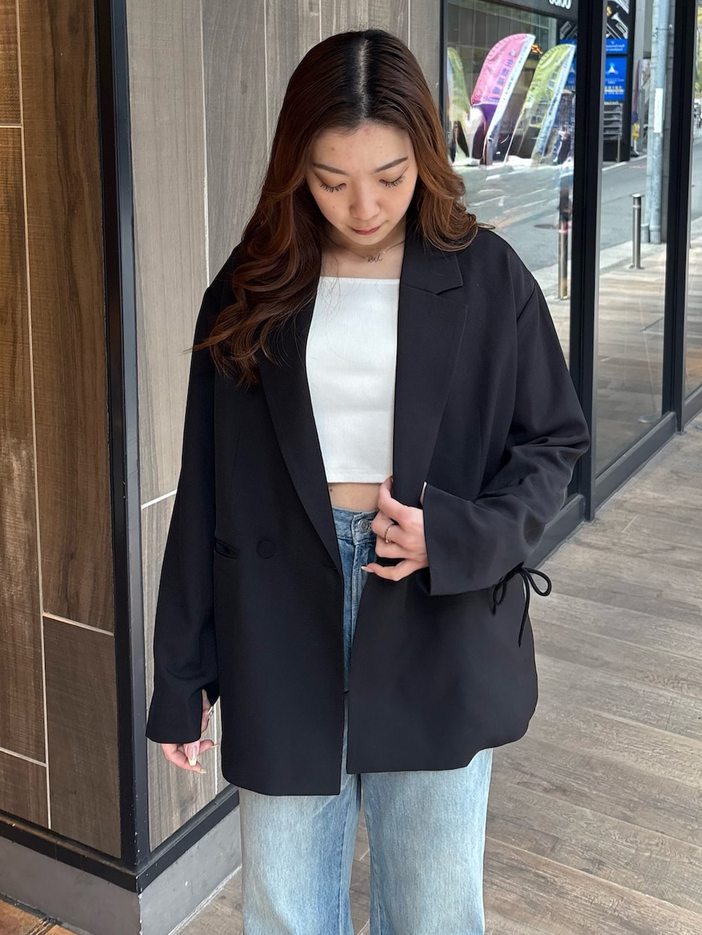 ブルー系のデニムパンツ、ブラック系のブーツ、ホワイト系のTシャツ/カットソーを着用したレディースの春コーディネートの4枚目の写真