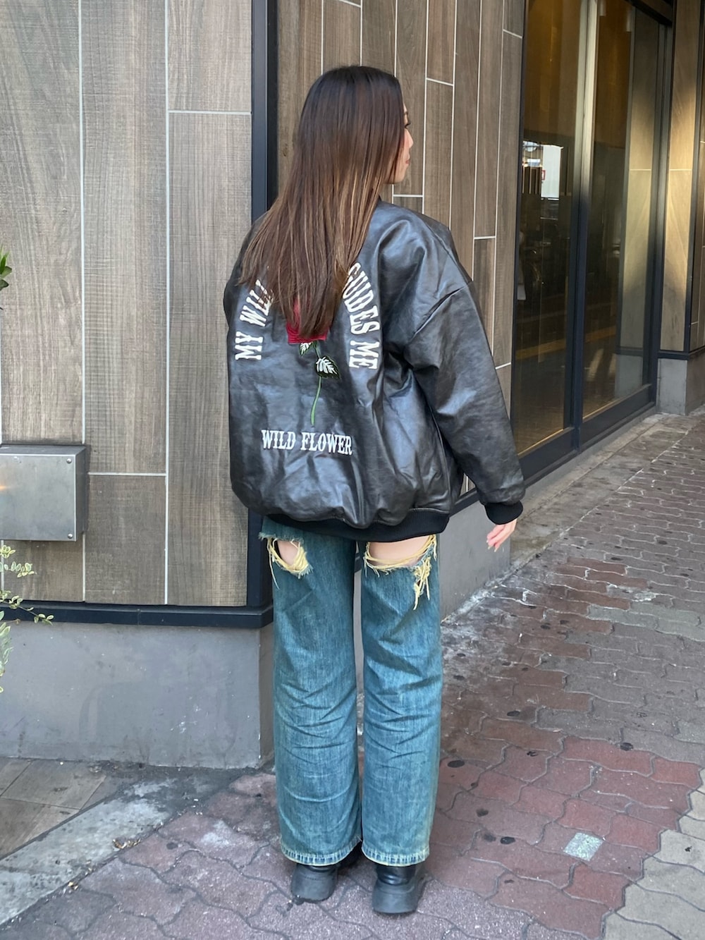 ブルー系のデニムパンツ、ブラック系のブーツ、ブラック系のスタジャンを着用したレディースの冬コーディネートの3枚目の写真