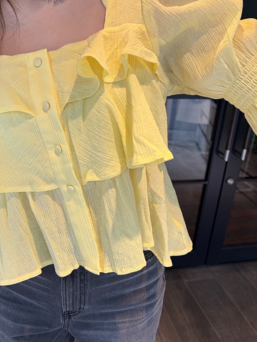 イエロー系のシャツ/ブラウス、ブラック系のデニムパンツ、ブラック系のブーツを着用したレディースの春コーディネートの5枚目の写真