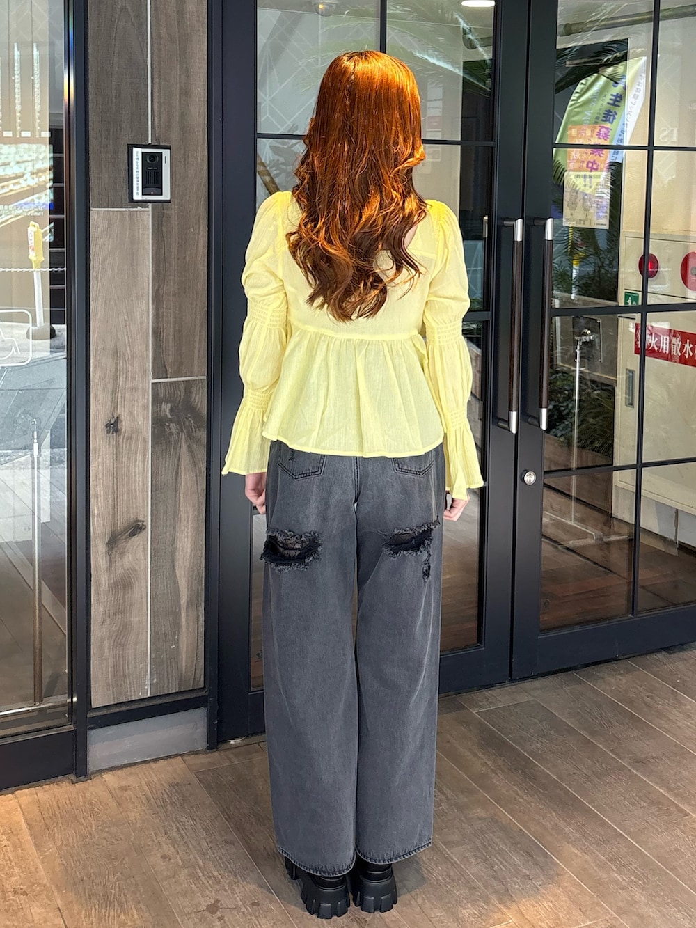 イエロー系のシャツ/ブラウス、ブラック系のデニムパンツ、ブラック系のブーツを着用したレディースの春コーディネートの3枚目の写真