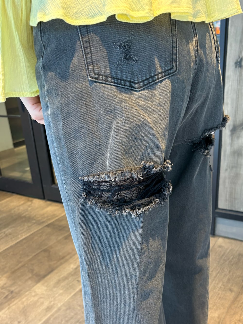 イエロー系のシャツ/ブラウス、ブラック系のデニムパンツ、ブラック系のブーツを着用したレディースの春コーディネートの6枚目の写真