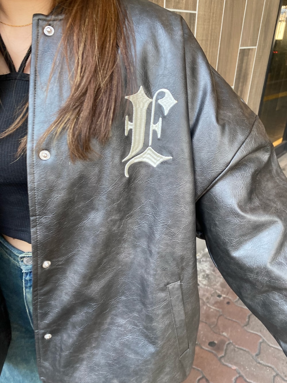 ブルー系のデニムパンツ、ブラック系のブーツ、ブラック系のスタジャンを着用したレディースの冬コーディネートの4枚目の写真