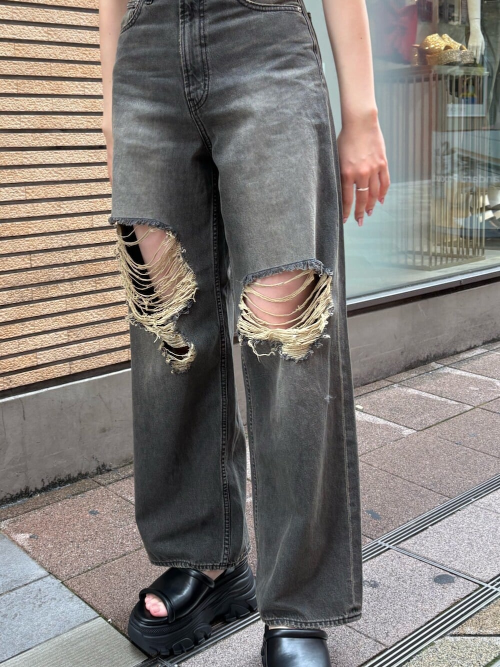 ブラック系のサンダル、ブラック系のデニムパンツ、ブルー系のニット/セーターを着用したレディースの夏コーディネートの5枚目の写真