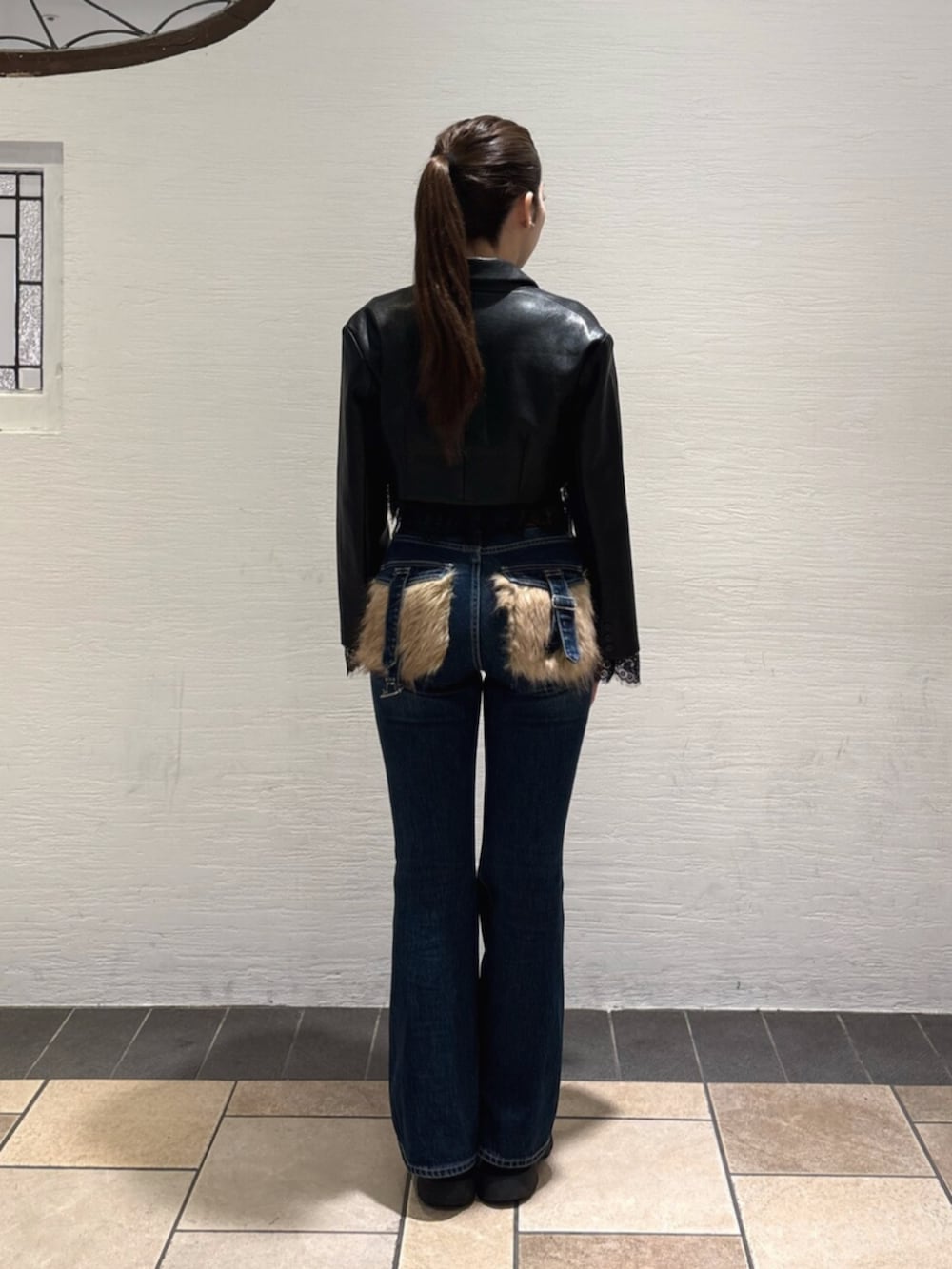 ブルー系のデニムパンツ、ブラック系のブーツ、ブラック系のTシャツ/カットソーを着用したレディースの秋コーディネートの3枚目の写真