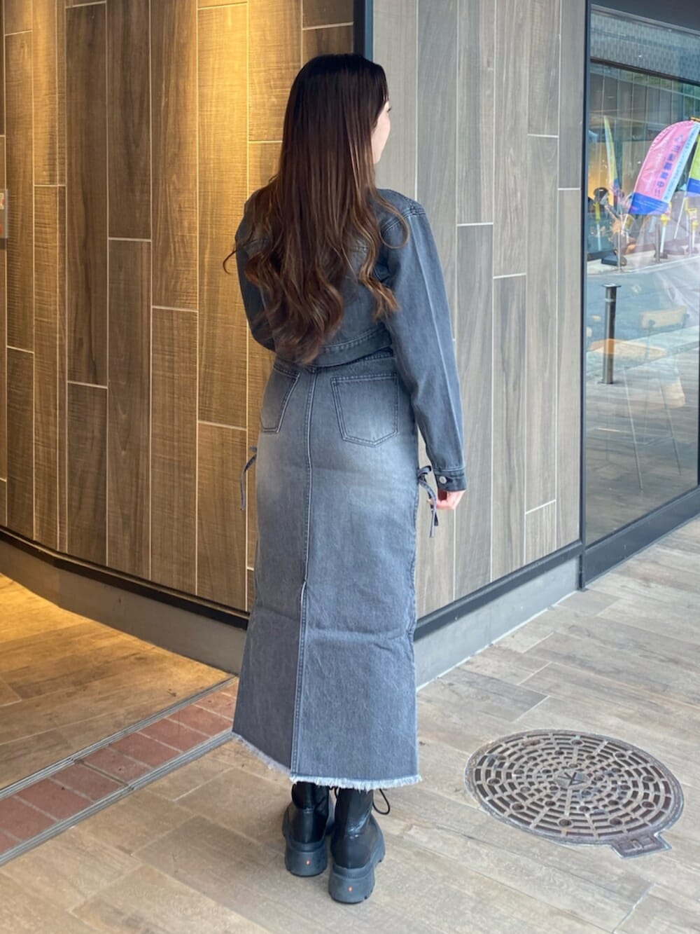 ブラック系のブーツ、ブラック系のTシャツ/カットソー、ブラック系のデニムジャケットを着用したレディースの冬コーディネートの3枚目の写真