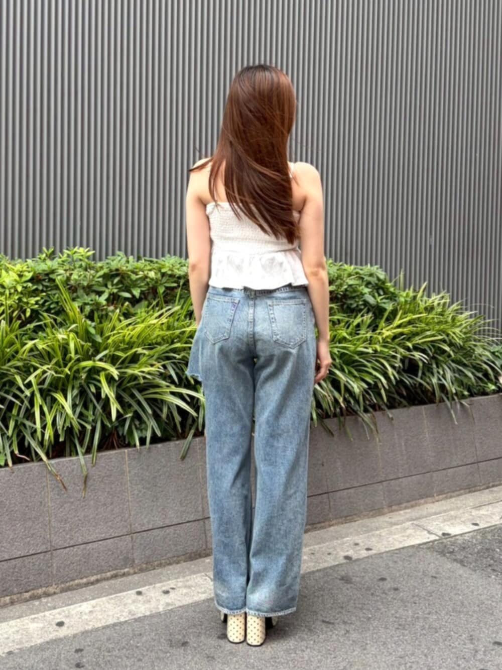 ホワイト系のキャミソール、ブルー系のデニムパンツ、ホワイト系のサンダルを着用したレディースの夏コーディネートの3枚目の写真