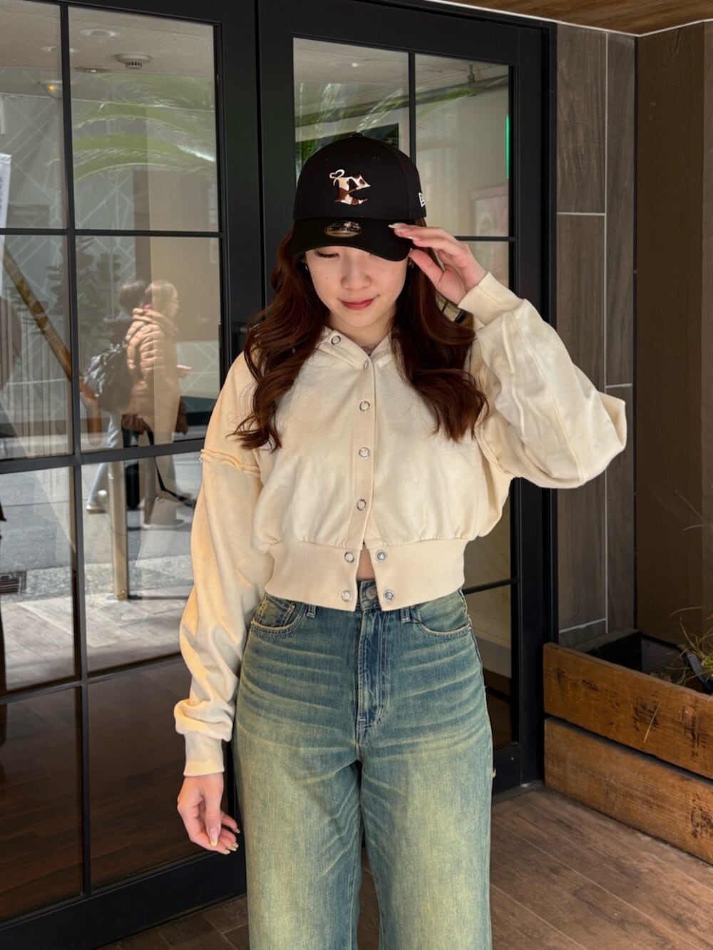 ブラック系のブーツ、ブルー系のデニムパンツ、ホワイト系のパーカーを着用したレディースの春コーディネートの4枚目の写真